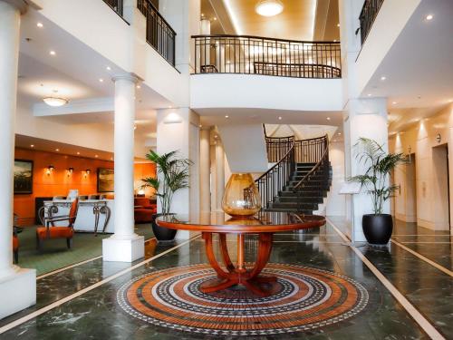 a lobby with a table and a staircase at The Sebel Quay West Auckland in Auckland