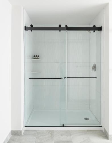 a shower with a glass door in a bathroom at ROOST White House in Washington, D.C.