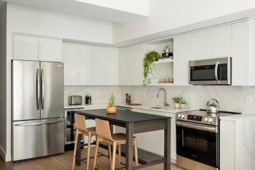 a kitchen with stainless steel appliances and a table with chairs at ROOST White House in Washington