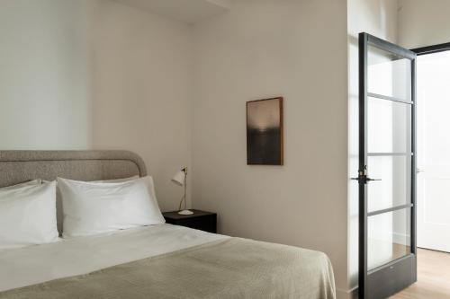 a bedroom with a white bed and a glass door at ROOST White House in Washington, D.C.