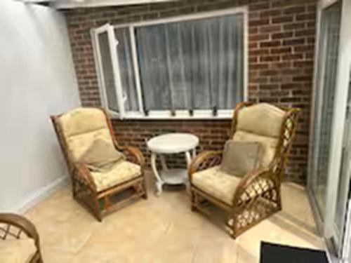 a balcony with two chairs and a table and a window at Emsworth Studio - With Hot tub only Oct to April in Emsworth