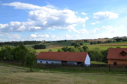 a white barn with a red roof in a field at Country house - Slapy/Pazderny in Žďár