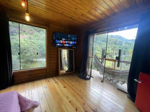 un salon avec une grande fenêtre et une télévision dans l'établissement Casa das Pedras - Um recanto de paz em Santa Tereza, à Santa Teresa