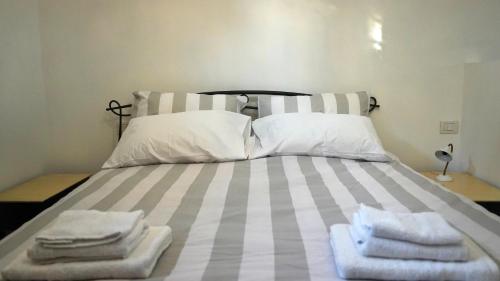 a bed with towels sitting on top of it at JD Suite Apartment near Ferrari in Fiorano Modenese
