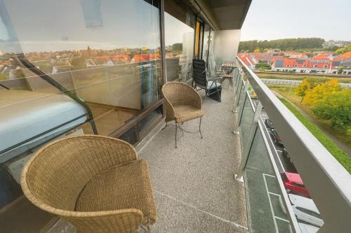 a balcony with chairs and a view of a city at Parking gratuit, piscine intérieur vue panoramique in Heist
