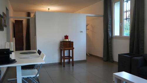 a living room with a table and a white wall at JD Suite Apartment near Ferrari in Fiorano Modenese