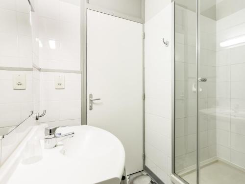 レスカーにあるibis budget Pau Lescarのシャワーと洗面台を備えた白いバスルーム