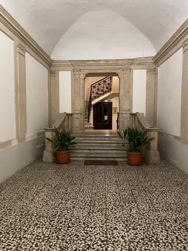 an empty room with stairs and potted plants at Palazzo Marini in Spoleto