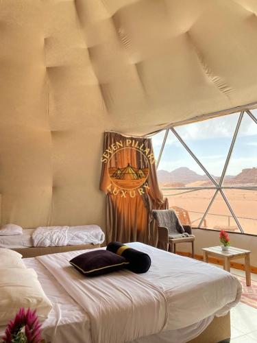 a bedroom with two beds and a view of the desert at SEVEN PILLARS lUXURY CAMP in Wadi Rum