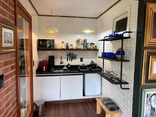 a kitchen with white cabinets and a counter top at Casa Jasmim em Domingos Martins a 5km do Centro in Domingos Martins