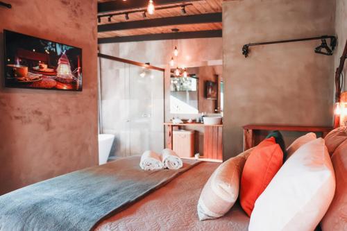 a bedroom with two pairs of slippers on a bed at Chalé Climatizado com banheira em frente ao Parque do Passaúna em Curitiba by Tiny House Passaúna in Curitiba