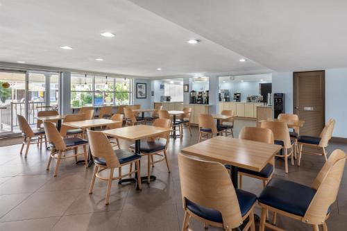 a dining room with wooden tables and chairs at Best Western Palm Beach Lakes in West Palm Beach