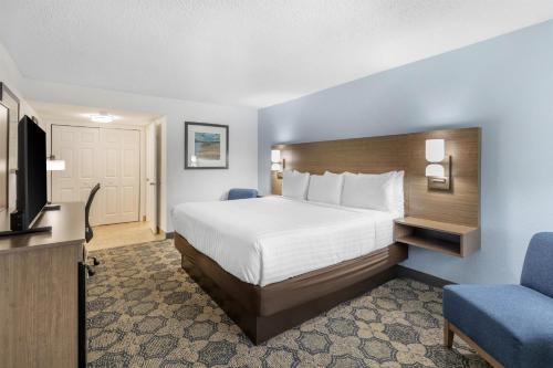 a hotel room with a bed and a tv at Best Western Palm Beach Lakes in West Palm Beach