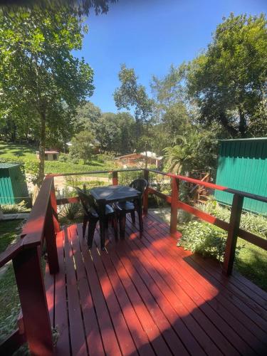a wooden deck with a table and chairs on it at Tiny House Passaúna - Climatizado, deck e parque in Curitiba