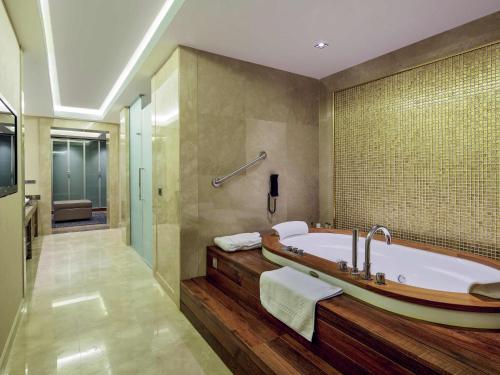 マラティヤにあるMovenpick Hotel Malatyaのバスルーム(バスタブ、ウォークインシャワー付)