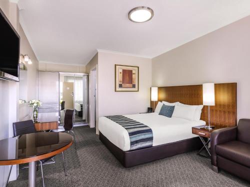 a hotel room with a bed and a desk at BreakFree Queanbeyan in Queanbeyan
