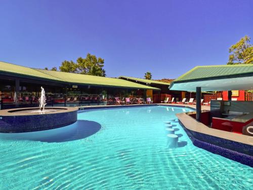 a swimming pool with a fountain in the middle of a building at Mercure Alice Springs Resort in Alice Springs