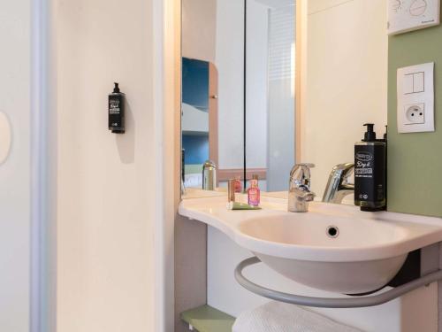 a bathroom with a sink and a mirror at ibis Budget Paris La Villette 19ème in Paris
