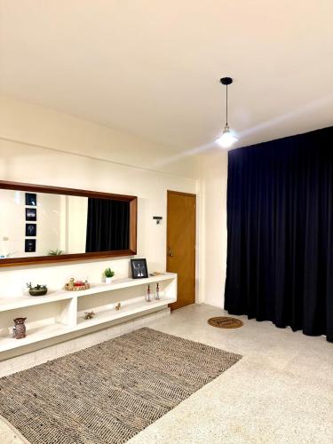 a living room with a large mirror and a blue curtain at Estancia pino suarez in Xalapa