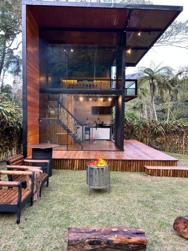 a house with a fire pit in a yard at Chalé Industrial Pedra do Imperador in Nova Friburgo