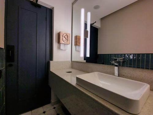 a bathroom with a sink and a large mirror at Hotel Soretti in Durango