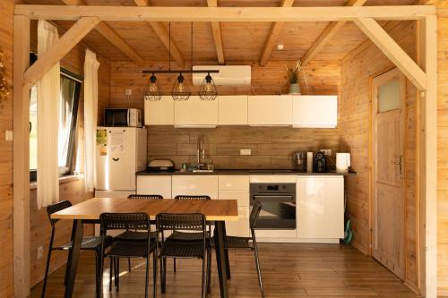 Una cocina con mesa y sillas en una cabaña. en Osada Krasne - Noclegi Blisko Natury, en Bukowiec
