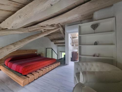 a bedroom with a large bed and a chair at Olga's Paradise in Santa Croce del Lago