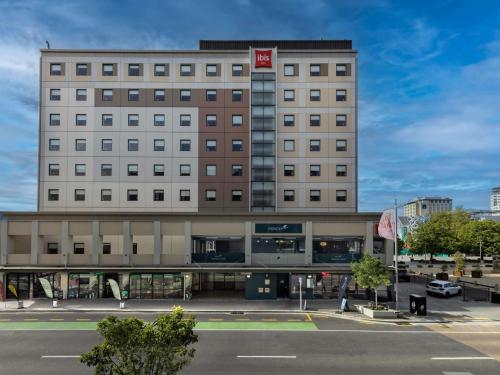 a large hotel building with a parking lot in front of it at Ibis Christchurch in Christchurch