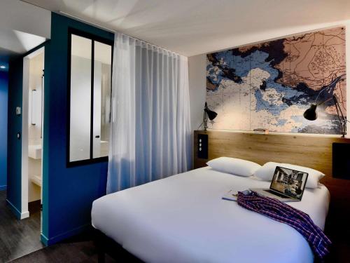 1 dormitorio con 1 cama grande y un mapa en la pared en ibis Styles Saint Nazaire Centre Gare, en Saint-Nazaire