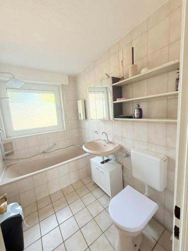 a bathroom with a toilet and a sink and a tub at FeWo W6 in Fürstenau