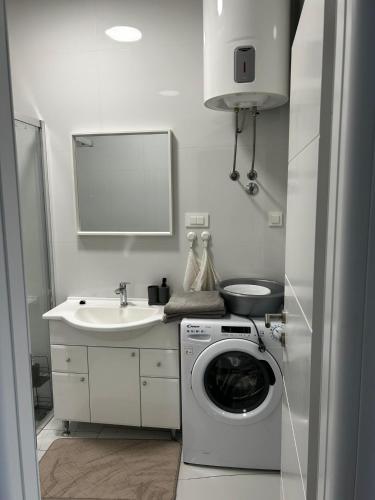 a white bathroom with a washing machine and a sink at Monami- Apartman Mia in Vodice