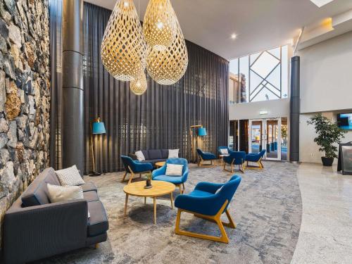 a lobby with couches and chairs in a building at Mantra Bunbury in Bunbury