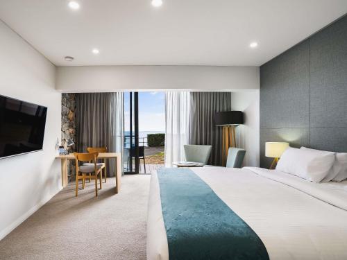 Una habitación de hotel con una cama grande y una mesa y sillas. en Mantra Bunbury, en Bunbury