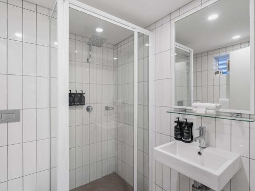 Un baño blanco con lavabo y ducha. en Mantra Bunbury, en Bunbury
