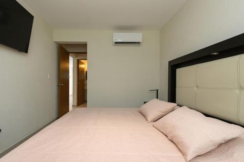 a bedroom with a large bed with two pillows at Residencial Diamante in Acapulco