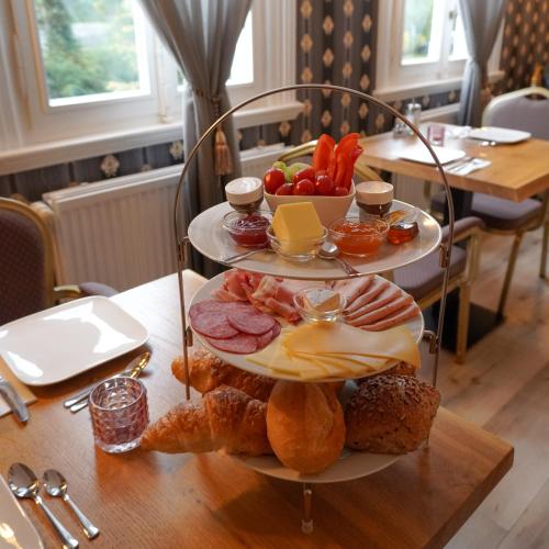 ein dreistufiges Tablett mit Lebensmitteln auf einem Tisch in der Unterkunft Villa Burgau in Monschau