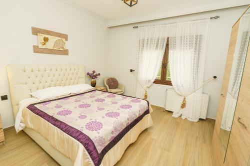 a bedroom with a bed with a purple and white blanket at Four lakes luxury suites in Amintaio