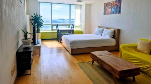 a room with a bed and a couch and a table at Cozy - Experience Home like Comfort Studio in Incheon