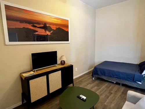 a small room with a bed and a tv at Alvaro Guest House in Rio de Janeiro
