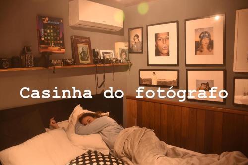 a woman laying in a bed in a bedroom at Casinha do Fotógrafo em Domingos Martins a 7km do Centro in Domingos Martins