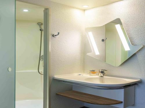 a bathroom with a sink and a mirror at ibis budget Paris Porte d'Italie Ouest in Le Kremlin-Bicêtre