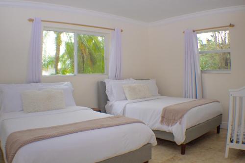 マイアミにあるDreampoolhousemiamiの白い部屋 ベッド2台 窓2つ付
