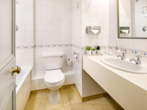 a bathroom with a toilet and a sink at Mercure Bristol North The Grange Hotel in Bristol
