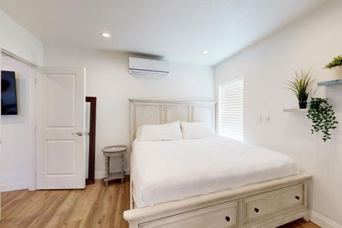 Un dormitorio blanco con una cama blanca y una ventana. en Fair Weather, en Newport Heights
