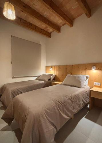 two beds in a room with a projection screen at La Plana allotjament rural in Aviá