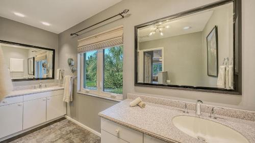a bathroom with two sinks and a large mirror at Gulf Birdie - 5551 in Siesta Key