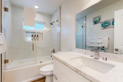a white bathroom with a sink and a toilet at Sunny Days in Newport Heights