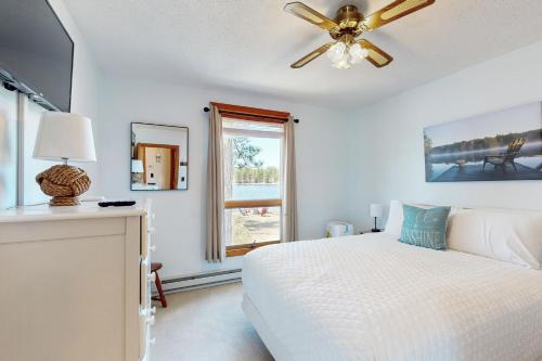 a white bedroom with a bed and a ceiling fan at Bayside Sunshine in Freedom