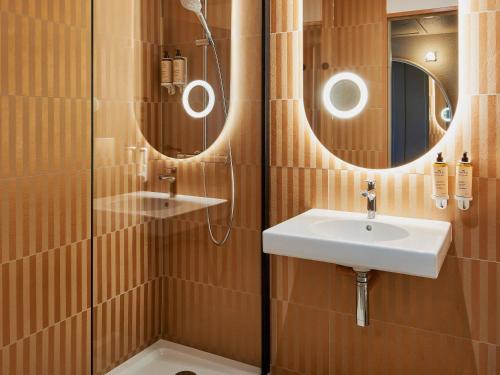 a bathroom with a sink and a shower at Mercure Saint Raphael Centre Plage in Saint-Raphaël