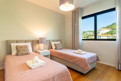 a bedroom with two beds and a large window at Leonor Seaview Apartment in Funchal